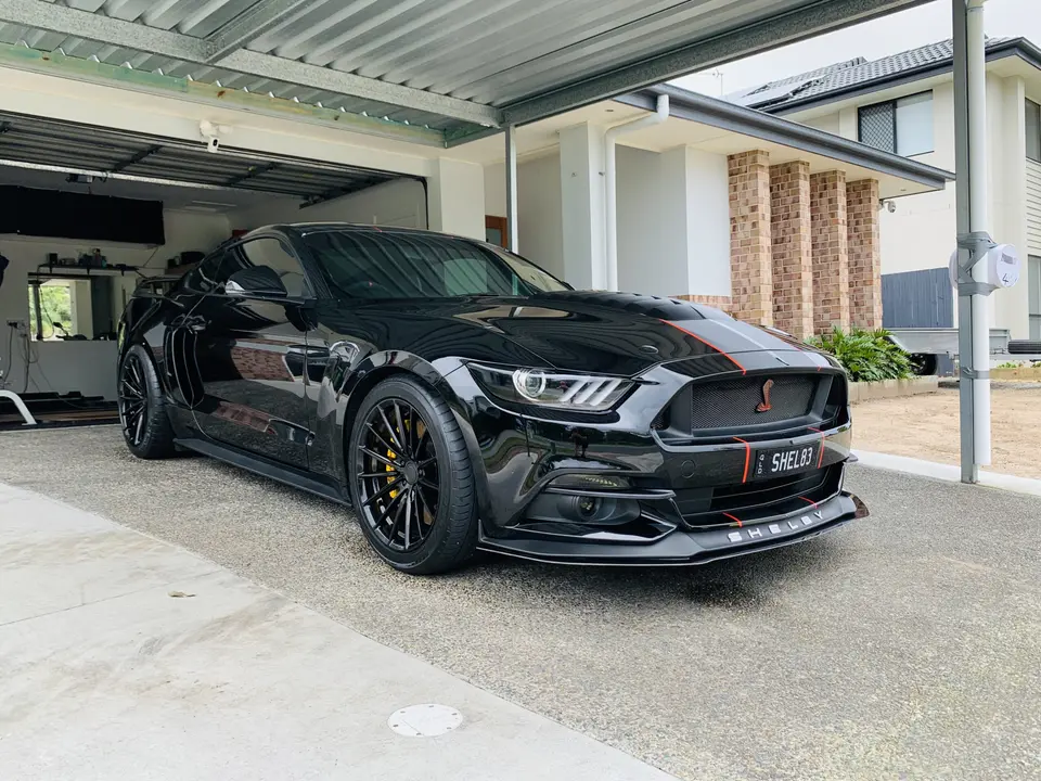 Headlights and front bodywork of a black Ford Mustang
